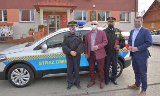 Wójt, Zastępca Wójta, Komendant  i Zastępca Straży Gminnej na tle samochodu