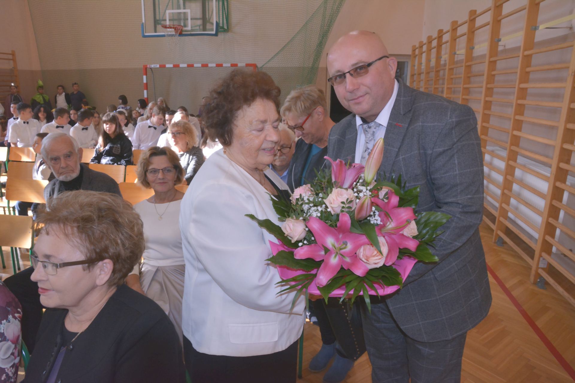Wójt Gminy Świlcza Adam Dziedzic wręcza bukiet kwiatów swojej nauczycielce Zofii Dziedzic
