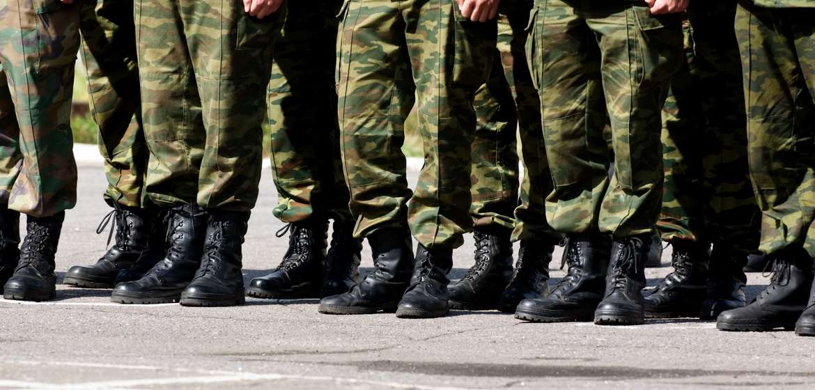 Widok nóg w wojskowych spodniach i butach